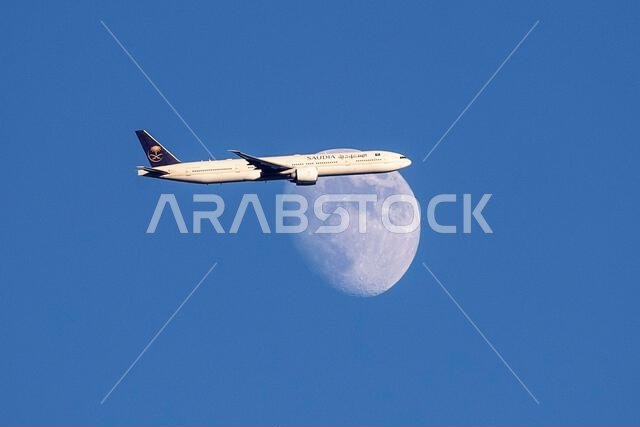 طائرة تابعة للخطوط الجوية السعودية من طراز إيرباص A350-900 تعبر القمر المتزايد فوق شمال لندن، المملكة المتحدة، أثناء اقترابها من مطار هيثرو.