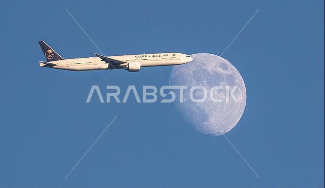 طائرة تابعة للخطوط الجوية السعودية من طراز إيرباص A350-900 تعبر القمر المتزايد فوق شمال لندن، المملكة المتحدة، أثناء اقترابها من مطار هيثرو.