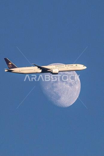 Saudi Arabian Airlines A350-900 plane passes the waxing moon above North London, United Kingdom as it approaches Heathrow Airport