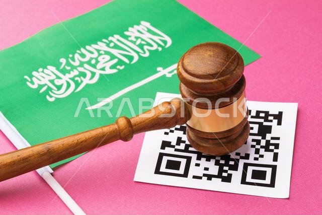 Judge gavel, barcode sheet and Saudi Arabia flag, concept of administrative punishment for violation of the regime using QR codes