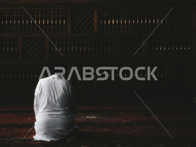 منظر من الخلف لرجل عربي سعودي خليجي يصلي في المسجد, أداء فريضة الصلاه داخل المسجد ،الخشوع في الصلاه ، العبادة و التقرب الى الله