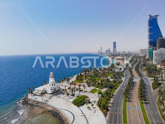 منظر جوي لمنتزه ساحلي جميل يضم أشجار النخيل وأفق المدينة في المملكة العربية السعودية
