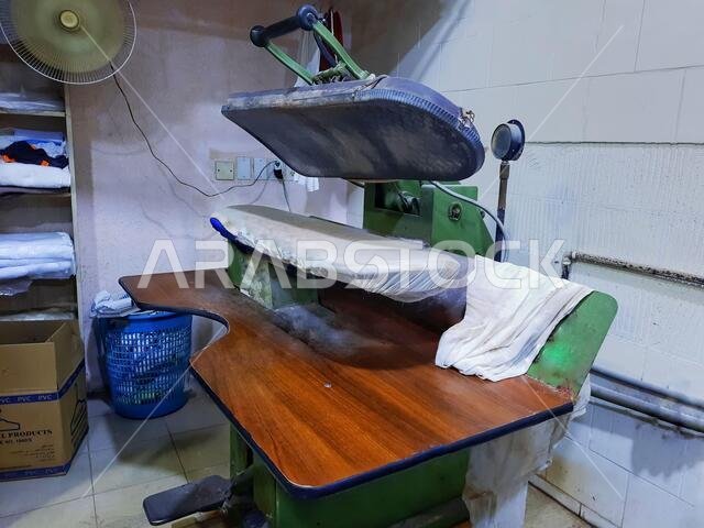 HOFUF AL HASA, SAUDI ARABIA - Aug 26, 2021: An old automatic ironing press machine in a laundry room