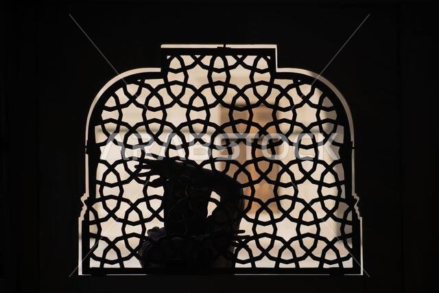 فتاة مسلمة ترتدي حجاباً أسود تقف خلف سياج من الحديد المطاوع المزخرف. فتاة مسلمة ترتدي حجاباً أسود تقف خلف سياج من الحديد المطاوع المزخرف.