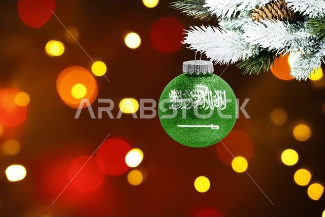 Colorful blurred background and applied the flag of Saudi Arabia on the New Year's toy. New Year 2022 Celebration