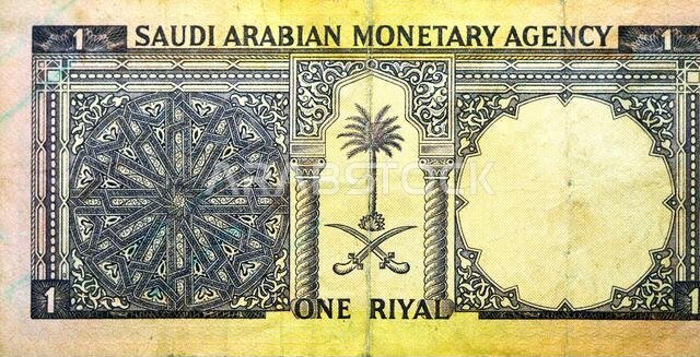 Large fragment of the reverse side of 1 one Saudi riyal banknote currency year 1961 features arms with 2 crossed swords and a palm tree, old Saudi mon