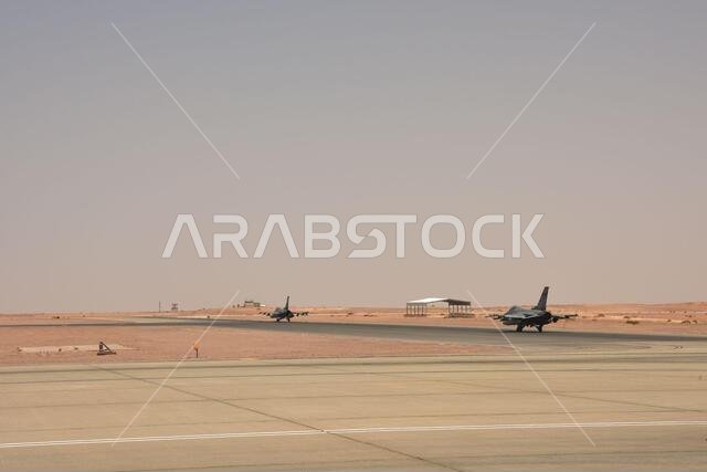 العقيد كريستوفر سميث، قائد مجموعة العمليات الاستكشافية 378، والرائد شون هولتج، طيار سرب المقاتلات الاستكشافية 157، يستعدان للرحلة على متن طائرتيهما المقاتلتين من طراز إف-16 فايتينغ فالكون في قاعدة الأمير سلطان الجوية، المملكة العربية السعودية، في 16 مايو 2021. وقد تم نشر طياري "ثعلب المستنقعات" من الحرس الوطني الجوي لولاية كارولاينا الجنوبية في قاعدة الأمير سلطان الجوية لتعزيز القوة القتالية والمساعدة في دعم القدرات الدفاعية ضد التهديدات المحتملة في المنطقة.