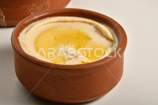 صورة مقربة لطبق فخاري من الحمص اللذيذ، أكلات عربية تقليدية، مأكولات عربية، أطباق شعبية، وصفات طعام لذيذة، وجبات الطعام الشهية، مطاعم شرقية، مطاعم للمأكولات العربية الشرقية، خلفية بيضاء