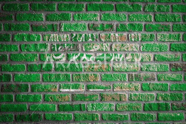 National flag of Saudi Arabia  depicting in paint colors on an old brick wall. Flag  banner on brick wall background.