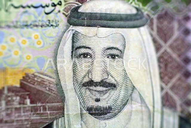 ورقة نقدية سعودية من فئة خمسة ريالات، خلفية العملة السعودية من فئة خمسة ريالات مع صورة الملك سلمان، تركيز انتقائي، وجه العملة السعودية