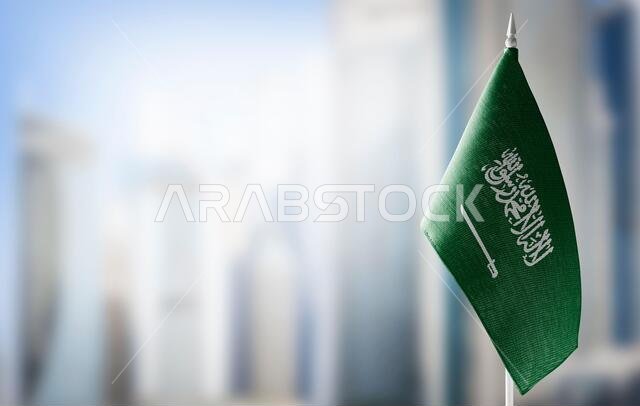 علم صغير للمملكة العربية السعودية على خلفية ضبابية