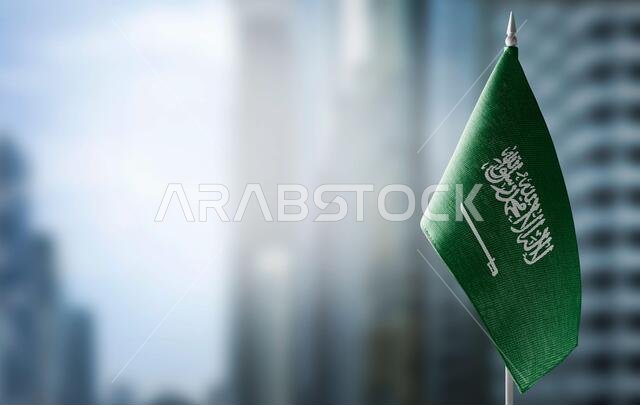 A small flag of Saudi Arabia on the background of a blurred background