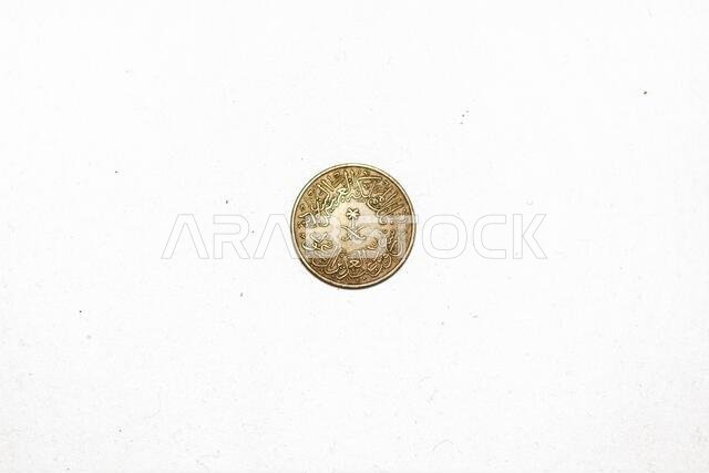 The obverse side of Saudi Arabia 1376 AH (year 1956) 4 Piasters GHIRSH (Qirsh) Coin with Uneven Toned-Luster isolated on white background, vintage ret The obverse side of Saudi Arabia 1376 AH (year 1956) 4 Piasters GHIRSH (Qirsh) Coin with Uneven Toned-Luster isolated on white background, vintage ret