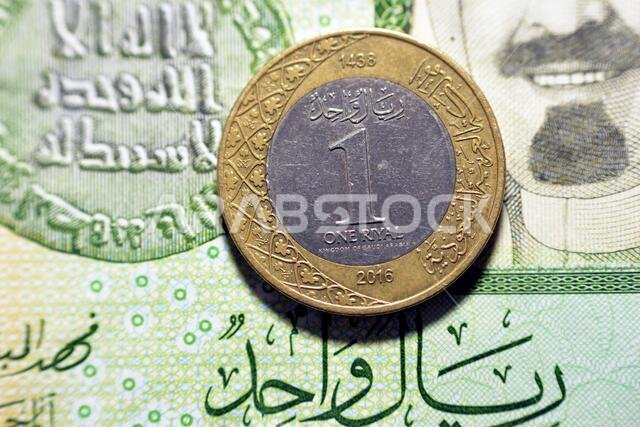 عملة معدنية من فئة ريال سعودي واحد (الوجه الخلفي) لعام 2016 على خلفية ورقة نقدية من فئة ريال سعودي واحد، ريال سعودي معدني وورقة نقدية معًا، سعودي