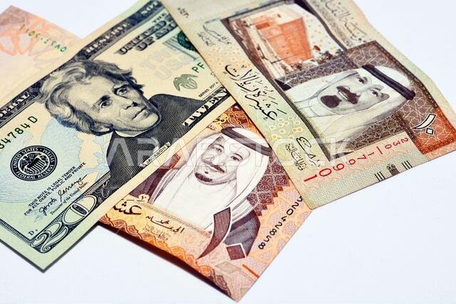 American 20 dollars with Saudi Arabia riyals currency banknotes of 10 Saudi Riyals with photo of king Salman and 10 Saudi Riyals with the photo of kin