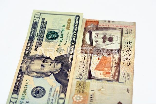 عملة أمريكية من فئة 20 دولارًا مع أوراق نقدية من فئة 10 ريالات سعودية عليها صورة الملك عبد الله، عملة أمريكية وريالات سعودية