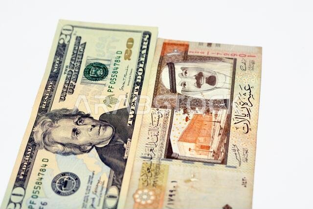 عملة أمريكية من فئة 20 دولارًا مع أوراق نقدية من فئة 10 ريالات سعودية عليها صورة الملك عبد الله، عملة أمريكية وريالات سعودية
