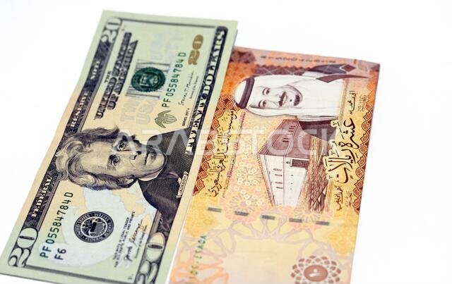 عملة أمريكية من فئة 20 دولارًا مع أوراق نقدية من فئة 10 ريالات سعودية تحمل صورة الملك سلمان، وعملة أمريكية وريالات سعودية. عملة أمريكية من فئة 20 دولارًا مع أوراق نقدية من فئة 10 ريالات سعودية تحمل صورة الملك سلمان، وعملة أمريكية وريالات سعودية.