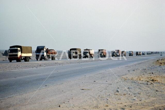 On the road coming from Saudi Arabia, a truck convoy arriving with merchandise in Doha city, state of Qatar. Slide picture taken in 1991 and scanned.