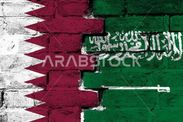 مفهوم العلاقة بين قطر والمملكة العربية السعودية من خلال علمين مرسومين على جدار من الطوب المتضرر