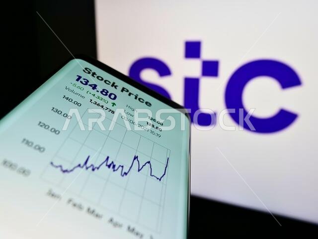 هاتف ذكي يعرض موقع شركة الاتصالات السعودية (STC) أمام شعار الشركة. ركّز على الزاوية العلوية اليسرى من شاشة الهاتف.