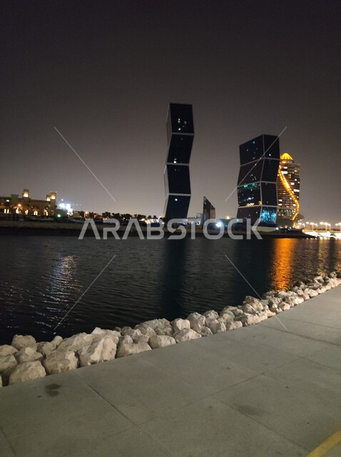 الابراج وناطحات السحاب مضاءة ليلا في مدينة الدوحة  في قطر ، الأبراج المتعرجه, الزقزاق, فنادق سياحيه, كورنيش الدوحه على شاطئ الخليج العربي ، اماكن سياحية ، السياحة في قطر