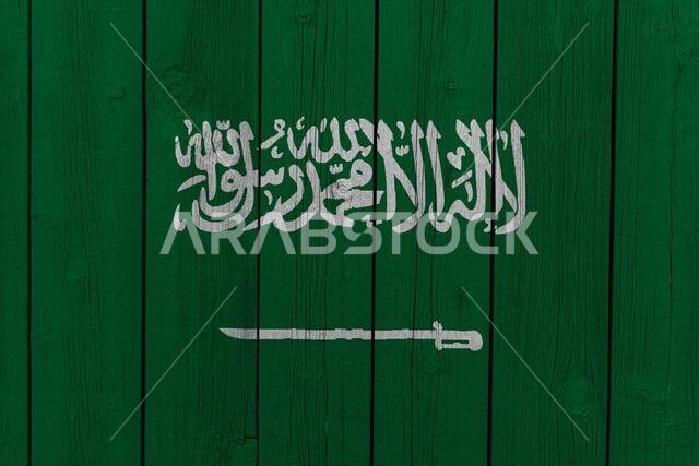 العلم الوطني للمملكة العربية السعودية مرسوم على جدار خشبي. العلم الوطني للمملكة العربية السعودية مرسوم على جدار خشبي.