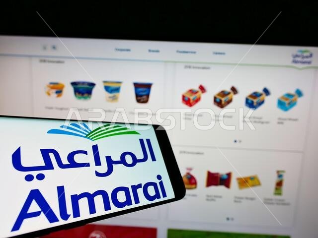 Smartphone with logo of Saudi Arabian dairy company Almarai Company on screen in front of business website. Focus on center-right of phone display.