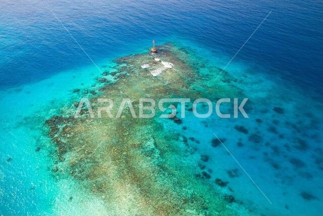 Shallow waters of Persian Gulf, Saudi Arabia. Red warning beacon with triangle top mark stands on a seabed