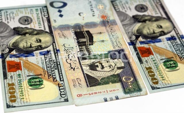 ورقة نقدية أمريكية من فئة مائة دولار وأوراق نقدية سعودية من فئة خمسمائة ريال (500 ريال سعودي)، عملة سعودية ودولارات أمريكية