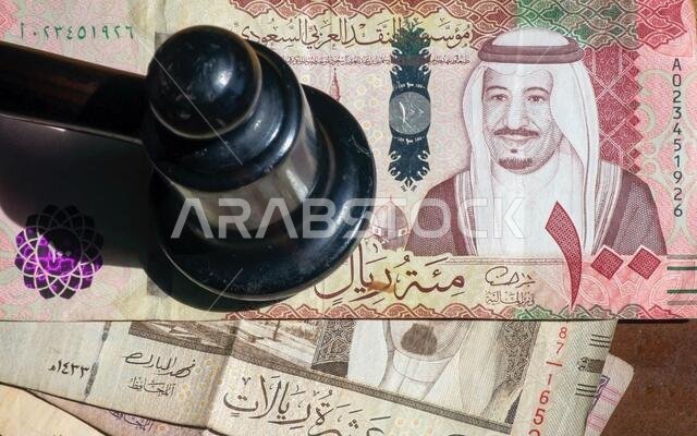 Judge hummer, Auctioneers Gavel or Hammer on Riyal, Saudi Arabian money, selected focus