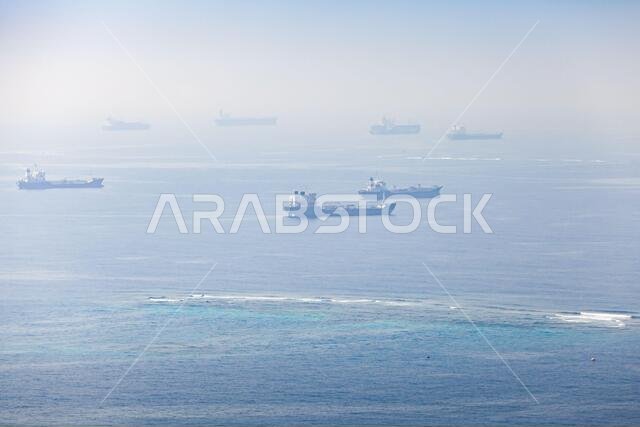 Industrial cargo ships are waiting for entrance to Jeddah port on a sunny day. Red Sea, Saudi Arabia Industrial cargo ships are waiting for entrance to Jeddah port on a sunny day. Red Sea, Saudi Arabia