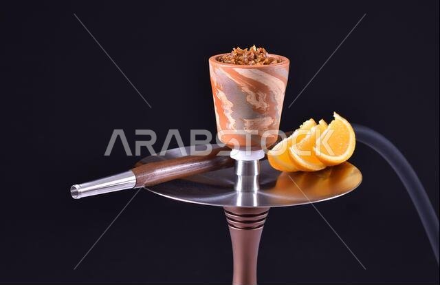 hookah bowl with tobacco on an black background with orange