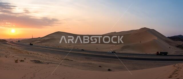 Sand dunes in Badr, Madinah, Saudi Arabia at sunset with the highway running through them. Tourism in KSA