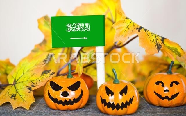 خلفية هالوين ملونة مع قرع مبتسم وعلم لعبة المملكة العربية السعودية