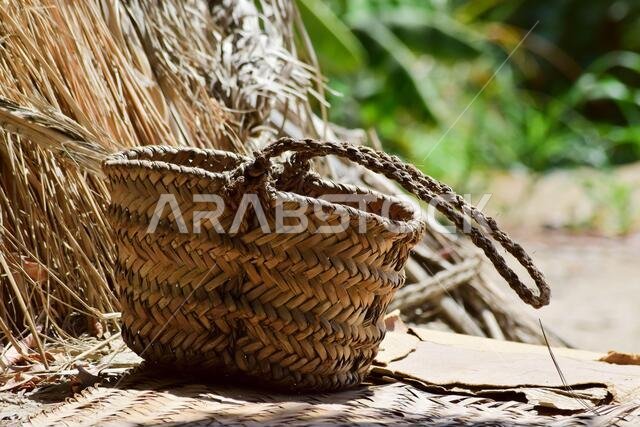 Hand made dates tree box tool, palm leaf dry jar hanging on wood in garden, brown background culture thing photo