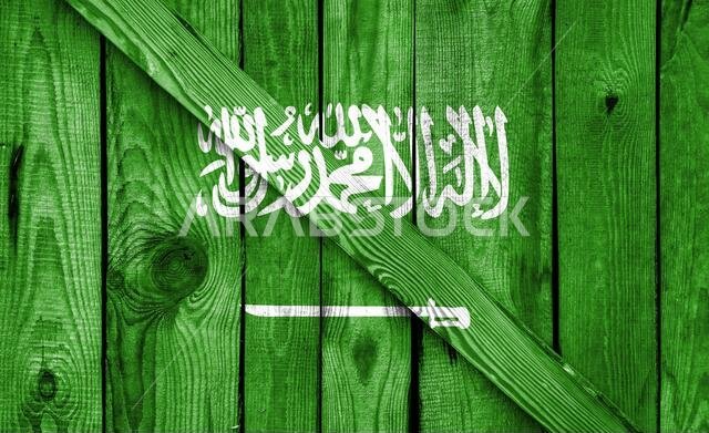 يظهر علم المملكة العربية السعودية على خلفية خشبية في صورة مقربة يظهر علم المملكة العربية السعودية على خلفية خشبية في صورة مقربة