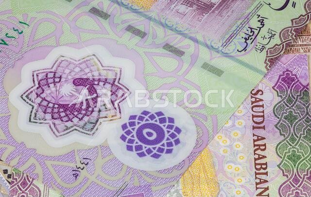 صورة مقرّبة لعملة سعودية. العملة الورقية السعودية. الريال السعودي بصورة الملك سلمان. هيئة النقد السعودية تكشف النقاب عنه