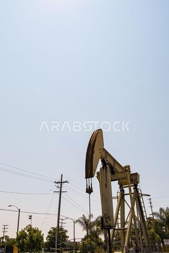 Rusty Crude Oil Pumper running against a light blue sunset sky