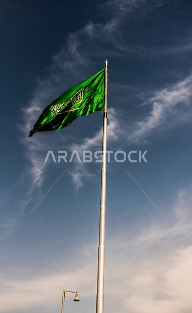 صورة مقربة لسارية علم السعودية يرفرف بالسماء، الاحتفال باليوم الوطني السعودي، حب الوطن، عيد الاستقلال السعودي، الاحتفال باليوم الوطني السعودي