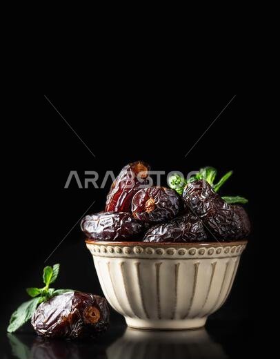 Dates fruit and rosary still life against a dark background. Ramadan background greeting card. Ramadan Kareem. Traditional culture of the Middle East.
