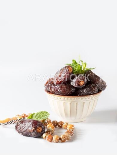 Dates fruit and rosary still life against on white background. Ramadan background greeting card. Ramadan Kareem. Traditional culture of the Middle Eas