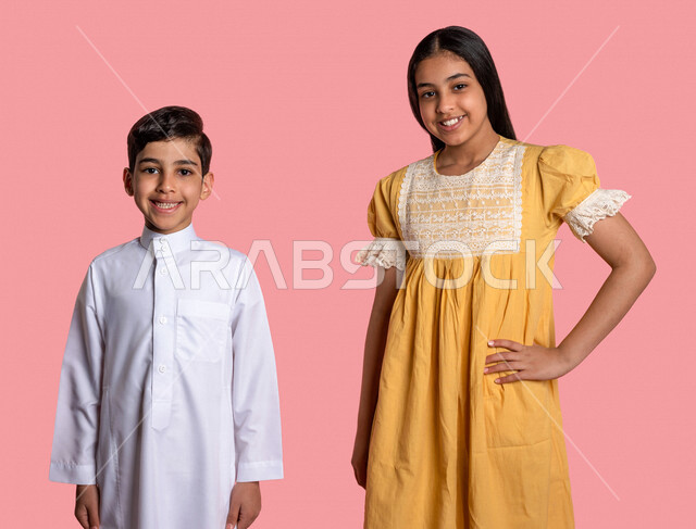 ورتريه لطفلان عربيان خليجيان سعوديان، العلاقات الأخوية المترابطة، علاقات اجتماعية، تعارف وصداقات، إيماءات وجه ويدين مختلفة تدل على السعادة، الوقوف بثقة، خلفية ملونة