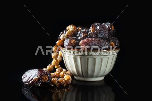Dates fruit and rosary still life against a dark background. Ramadan background greeting card. Ramadan Kareem. Traditional culture of the Middle East.