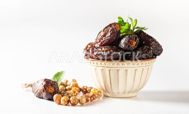 Dates fruit and rosary still life against on white background. Ramadan background greeting card. Ramadan Kareem. Traditional culture of the Middle Eas