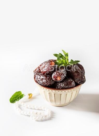 Dates fruit and rosary still life against on white background. Ramadan background greeting card. Ramadan Kareem. Traditional culture of the Middle Eas