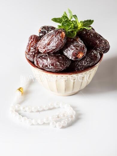 Dates fruit and rosary still life against on white background. Ramadan background greeting card. Ramadan Kareem. Traditional culture of the Middle Eas
