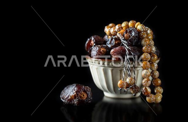 Dates fruit and rosary still life against on white background. Ramadan background greeting card. Ramadan Kareem. Traditional culture of the Middle Eas