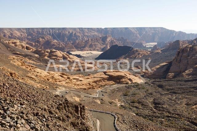 طريق متعرج بالقرب من العلا، يؤدي عبر وادٍ جاف إلى نقطة مشاهدة، المملكة العربية السعودية
