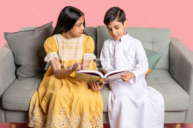 بورتريه لطفلان عربيان خليجيان سعوديان يستمتعان بالقراءة، قراءة الكتب، كتاب مدرسي، قصص وروايات، اكتساب المعرفة، تعليم وثقافة، خلفية ملونة